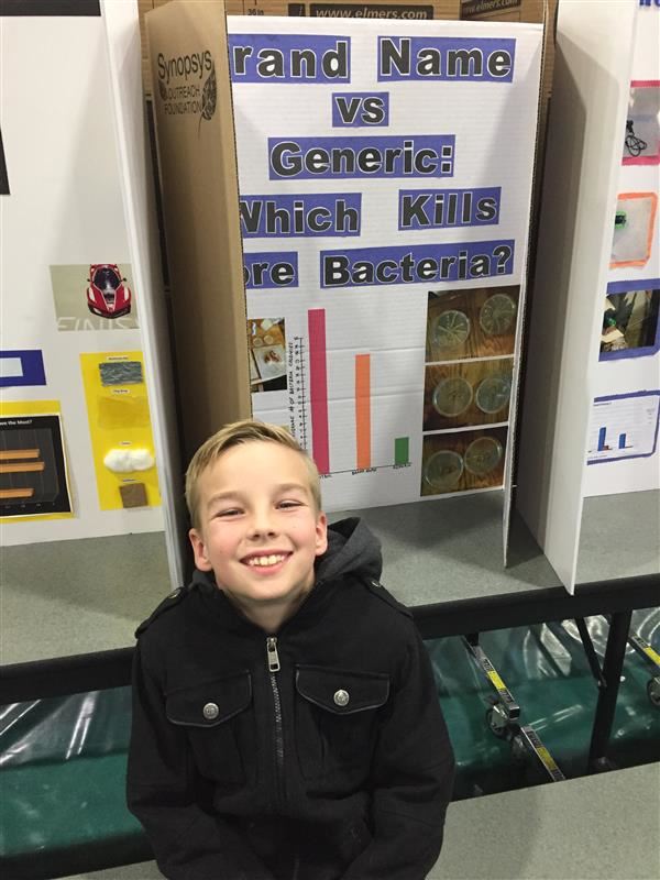 Newman Elementary School fourth-grader Joshua Hyatt smiles as he sits in front of his science fair project.